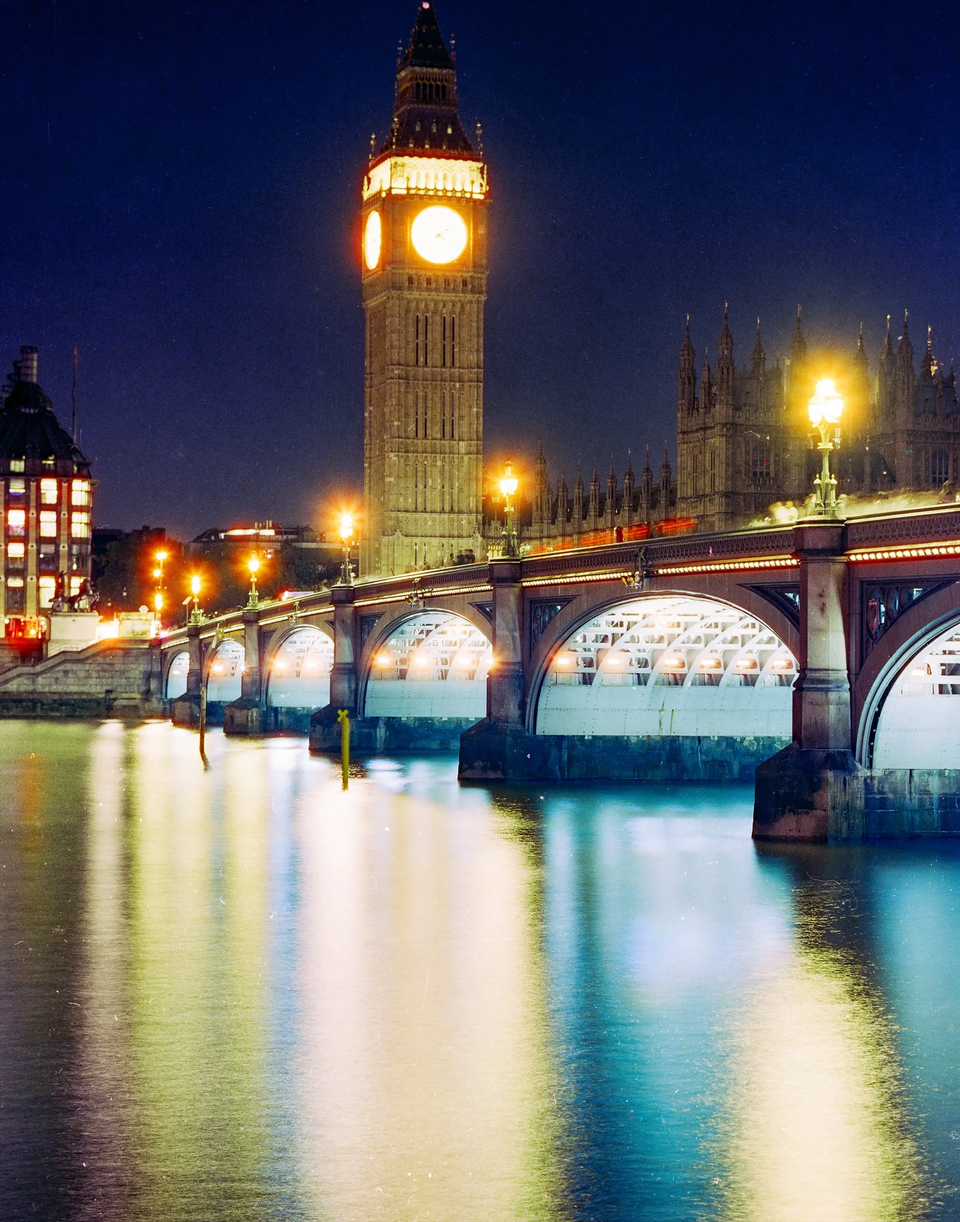 Big Ben and Westminster Bridge glowing over the Thames at night